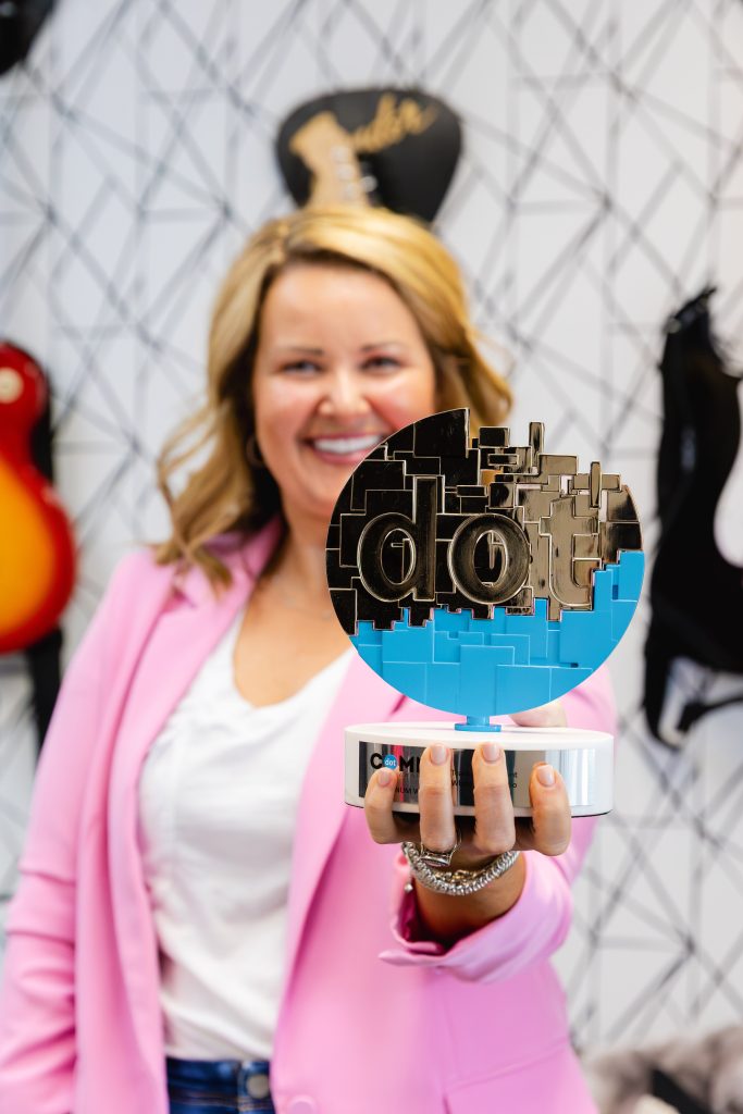 Mollie of White Label Studio holding a dotComm Award trophy