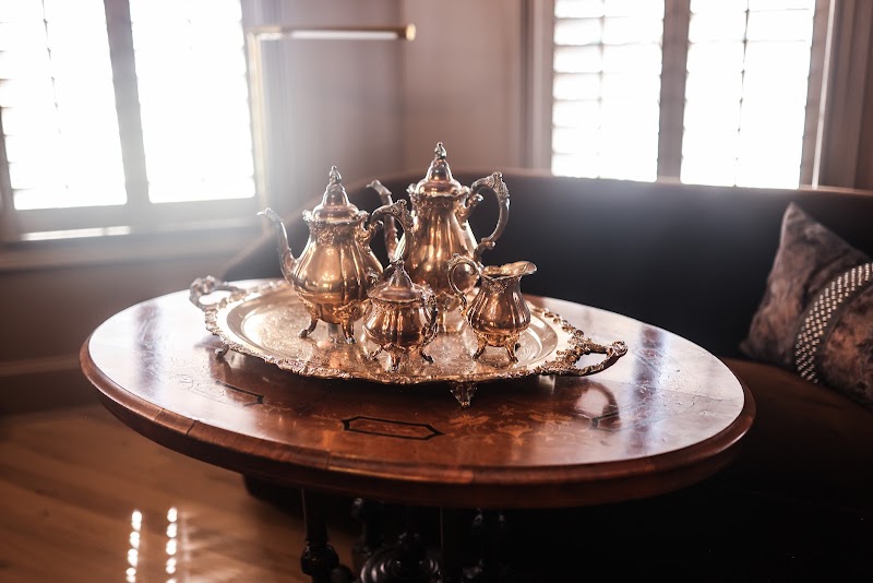 Antique tea table styled with a silver tea set in the Primary Bedroom sitting nook