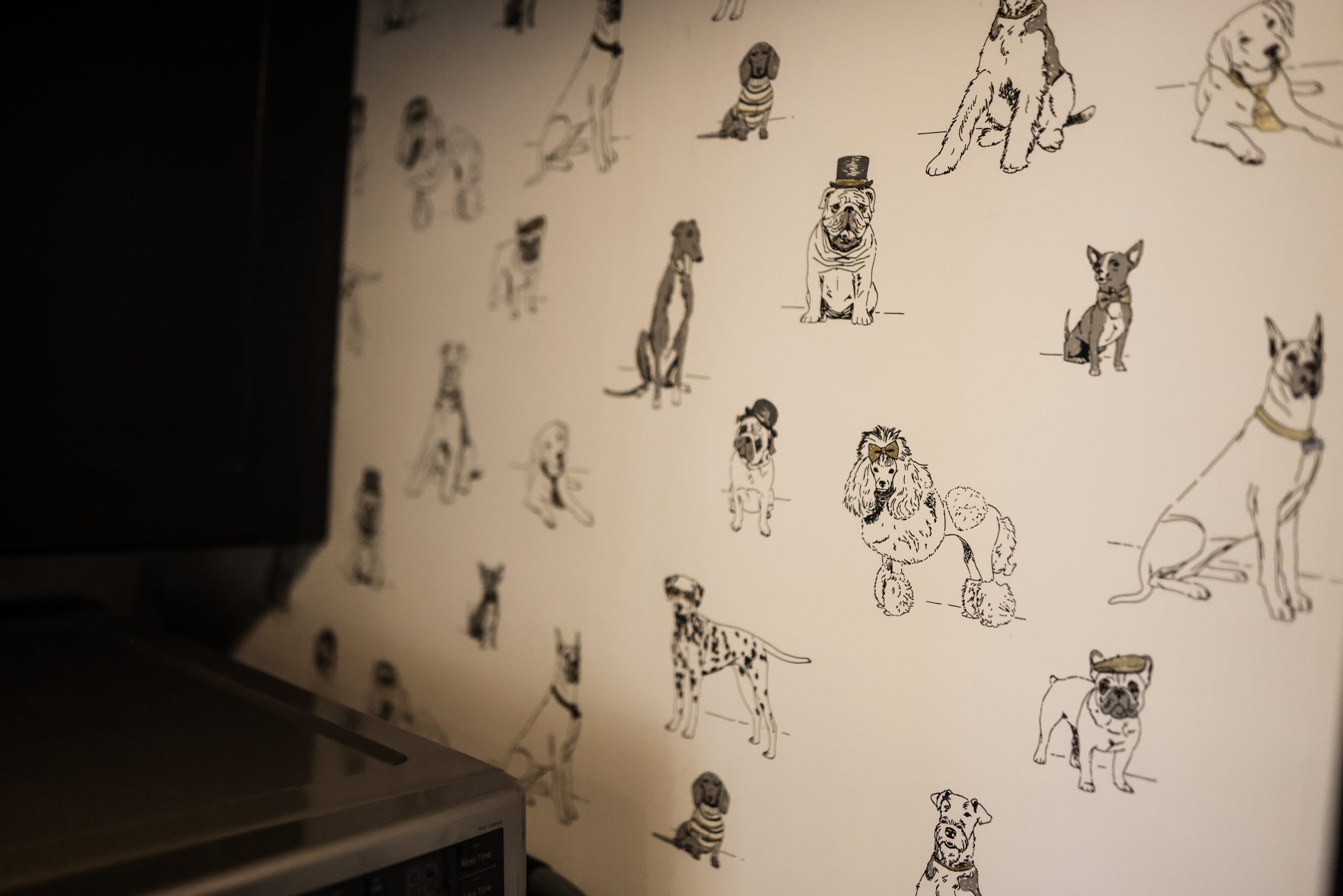 Close-up of the playful dog-themed wallpaper from Ballard Designs in the laundry room