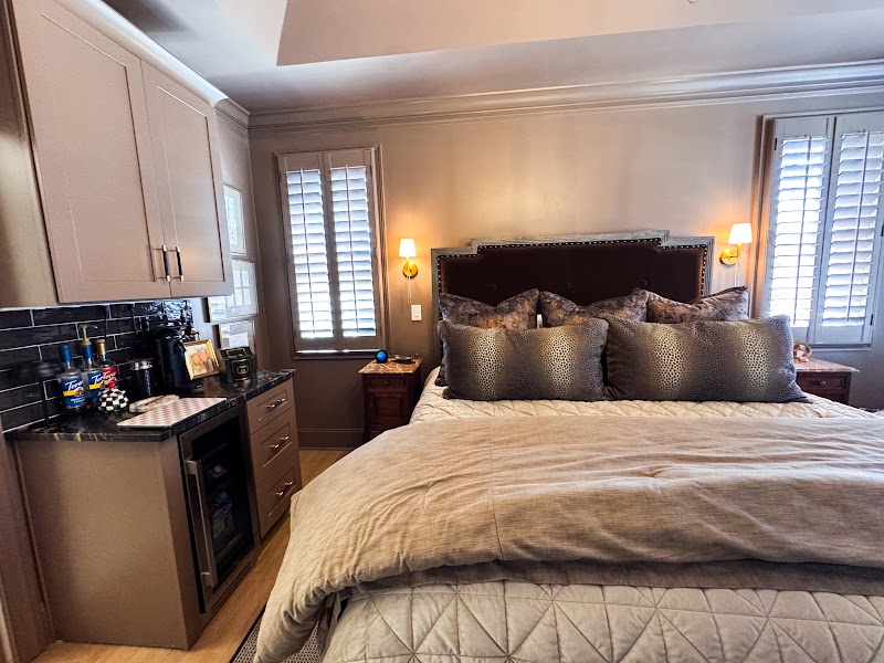 Built-in coffee bar in the Primary Bedroom with painted cabinets, dark subway tile backsplash, and integrated mini-fridge