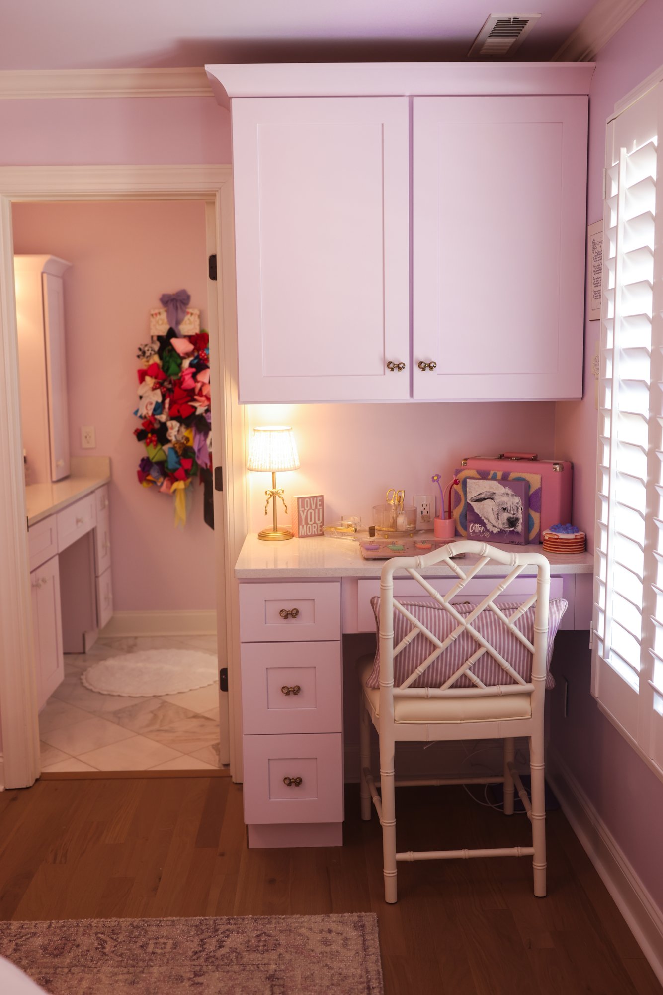 Lavender-washed desk with a white bamboo-style chair in Charlotte's bedroom