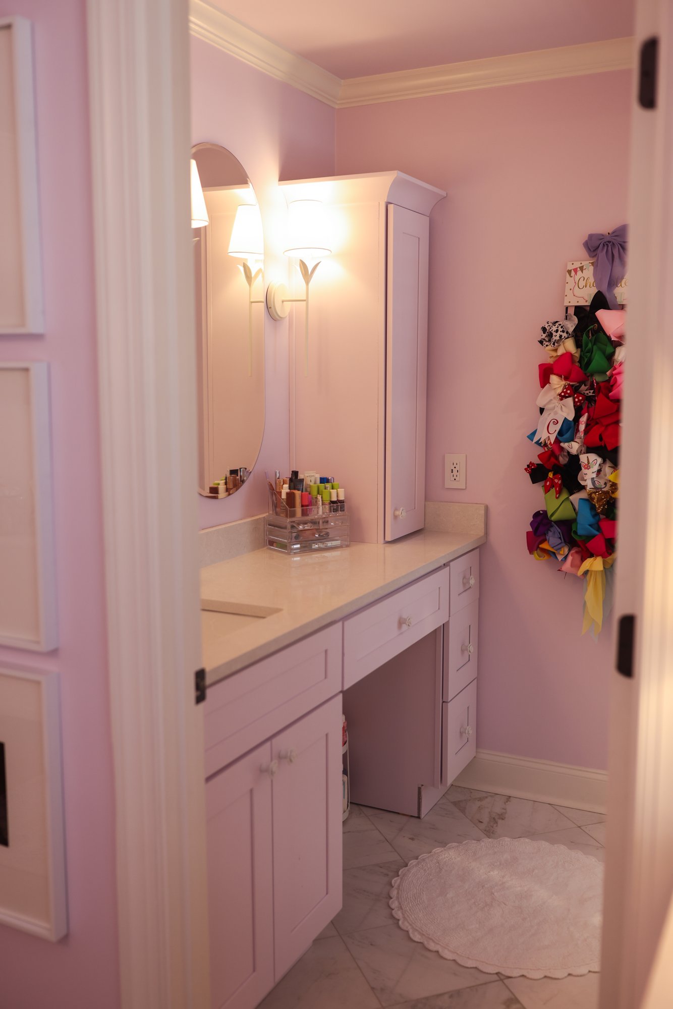 Lavender-painted bathroom vanity with a mirror and sconces