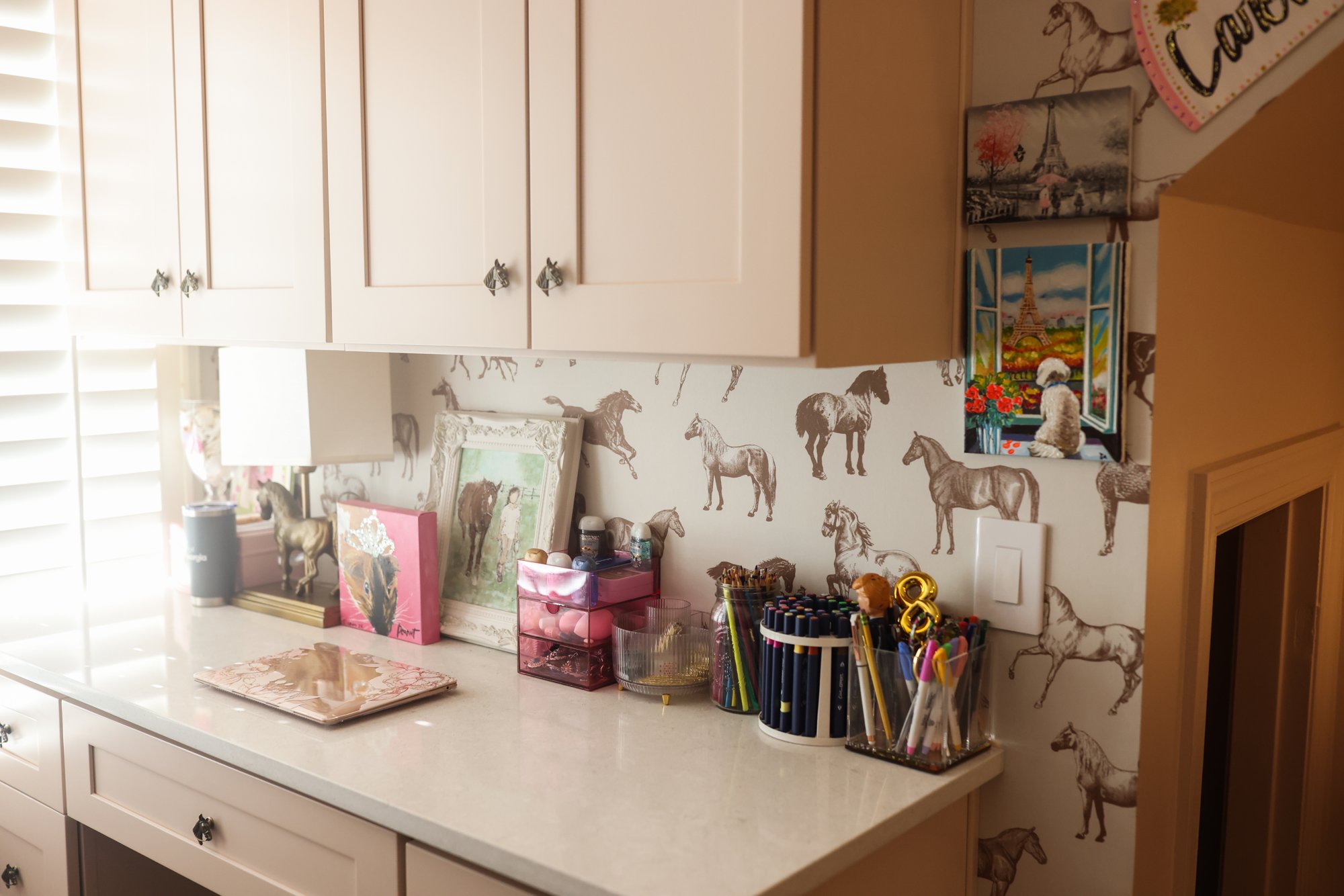 Caroline's desk area with white cabinetry and quarter horse wallpaper