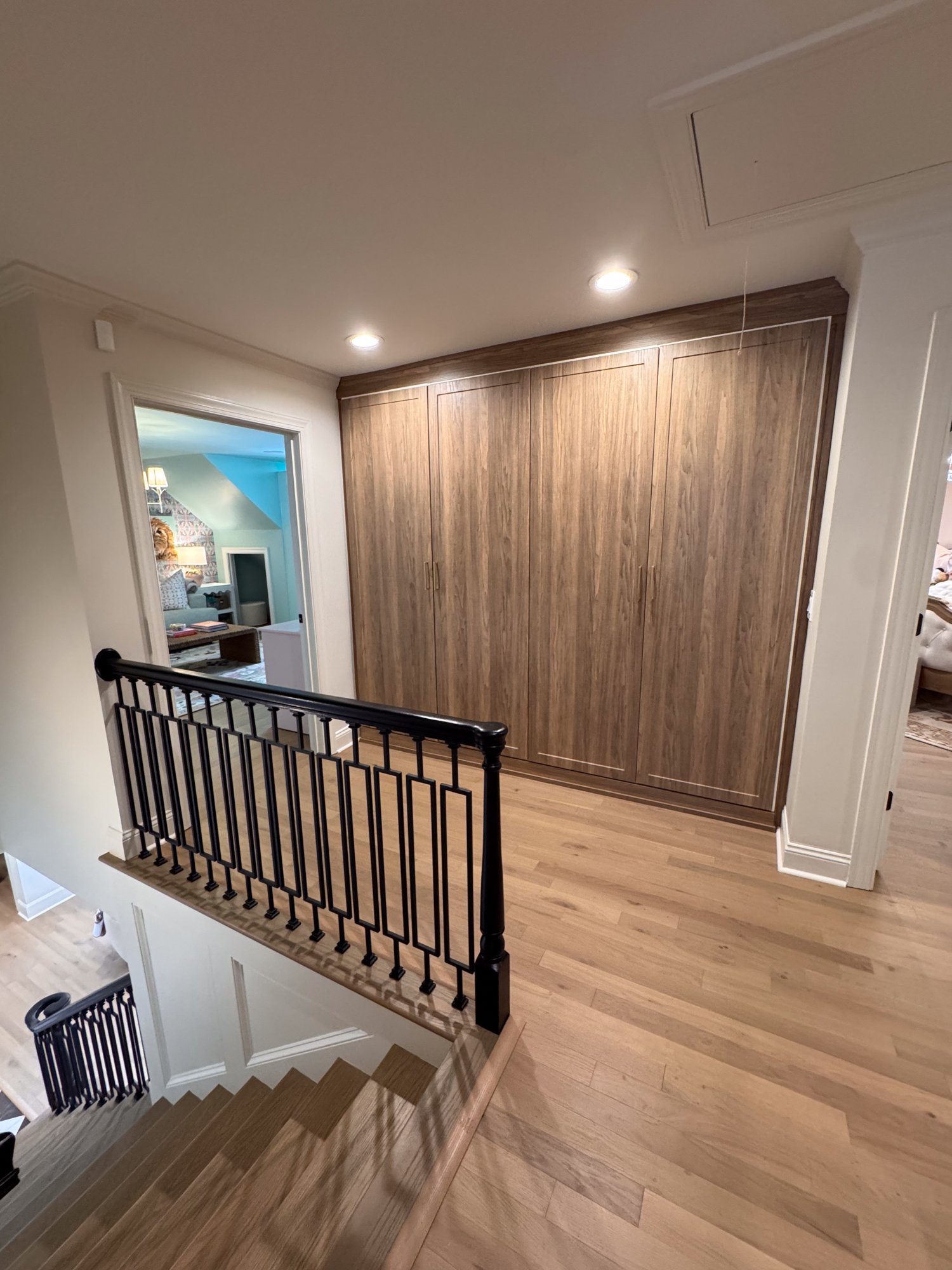 Custom wood-front mudroom locker wall built into the upstairs hallway alcove