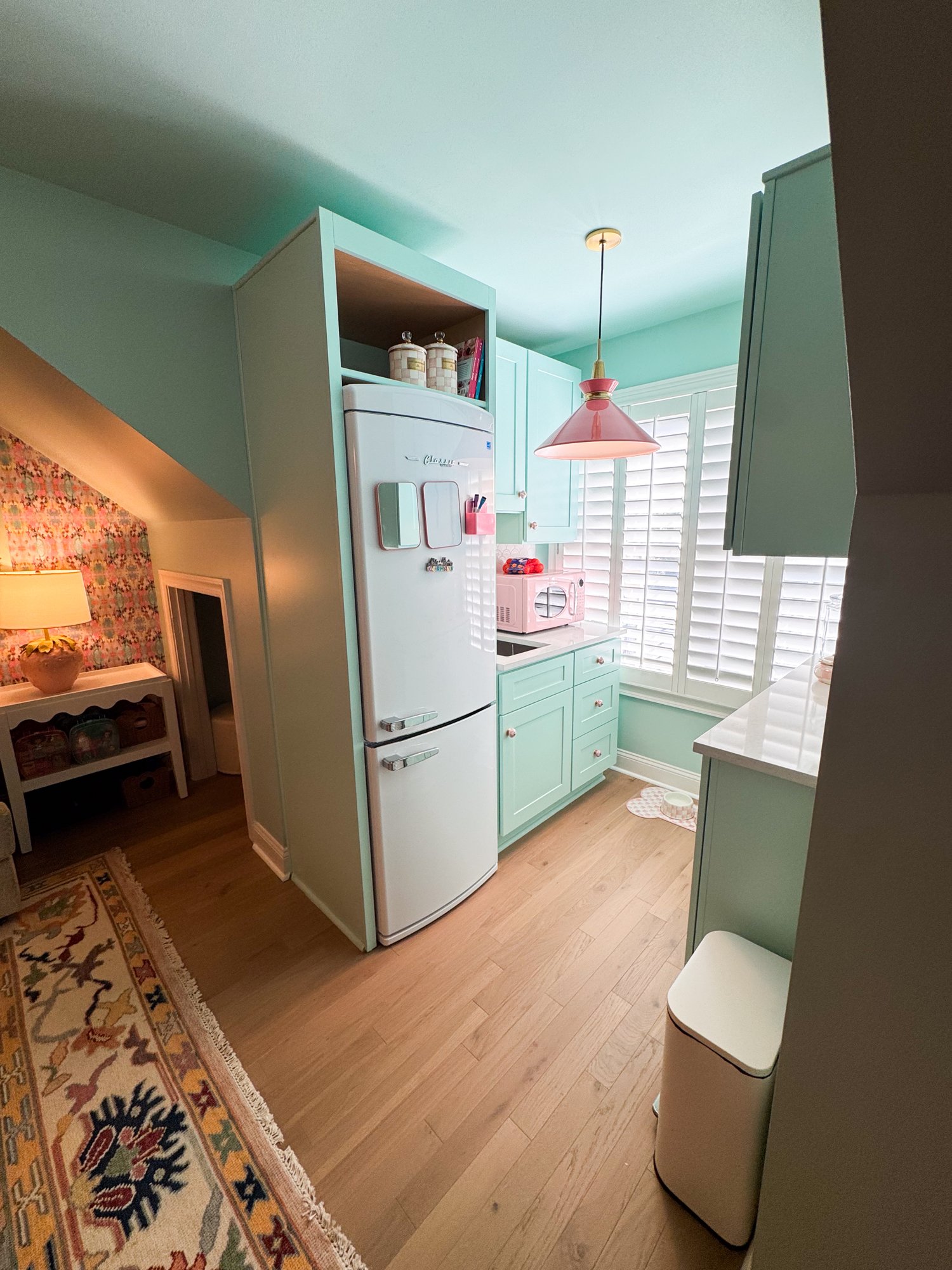 Playroom snack bar with a retro fridge and mint green cabinetry
