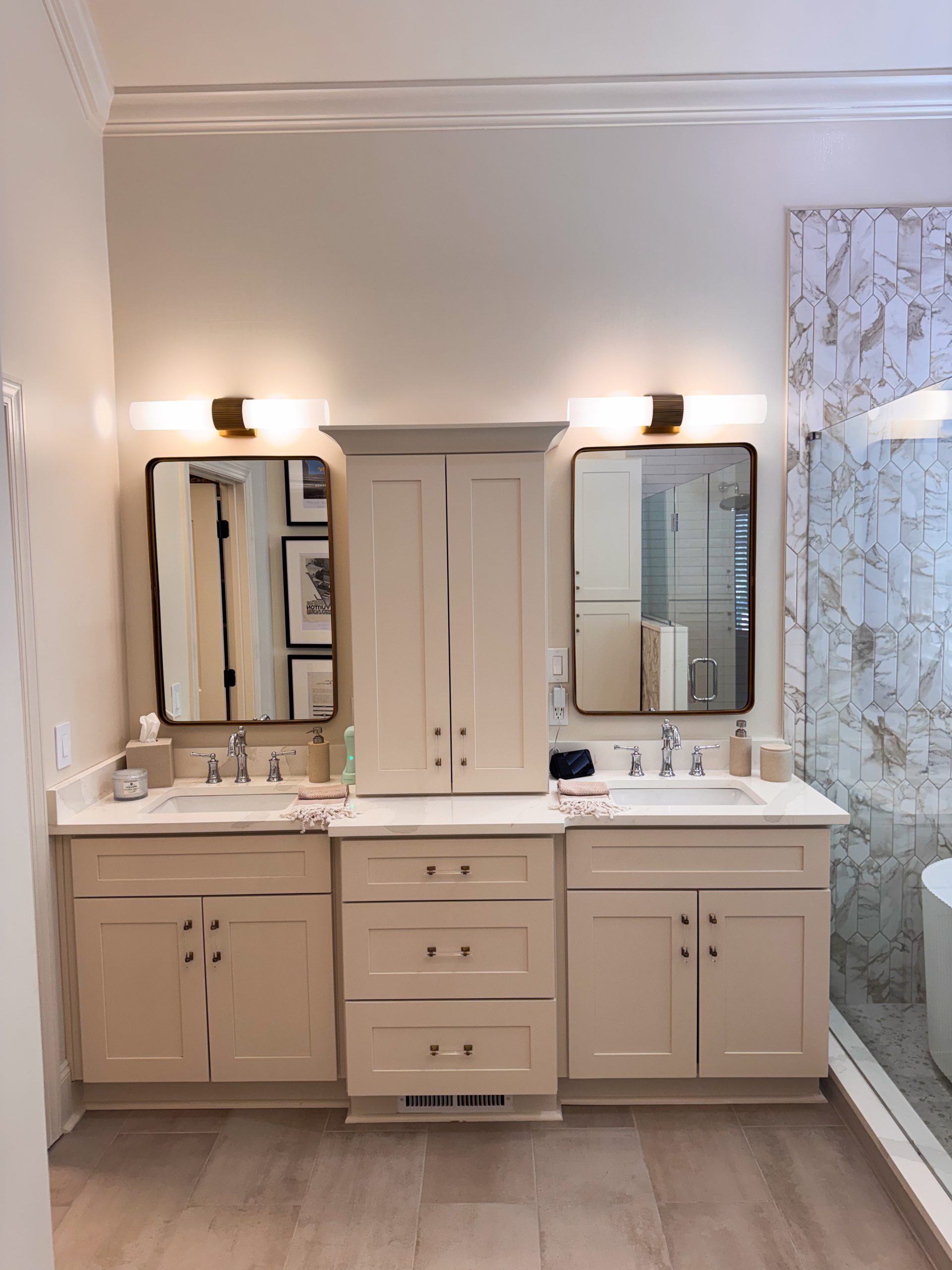 Double vanity with brass-accented mirrors and sconces in the primary bathroom wet room renovation